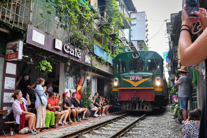 Watch the train cross the capital while enjoying an egg coffee